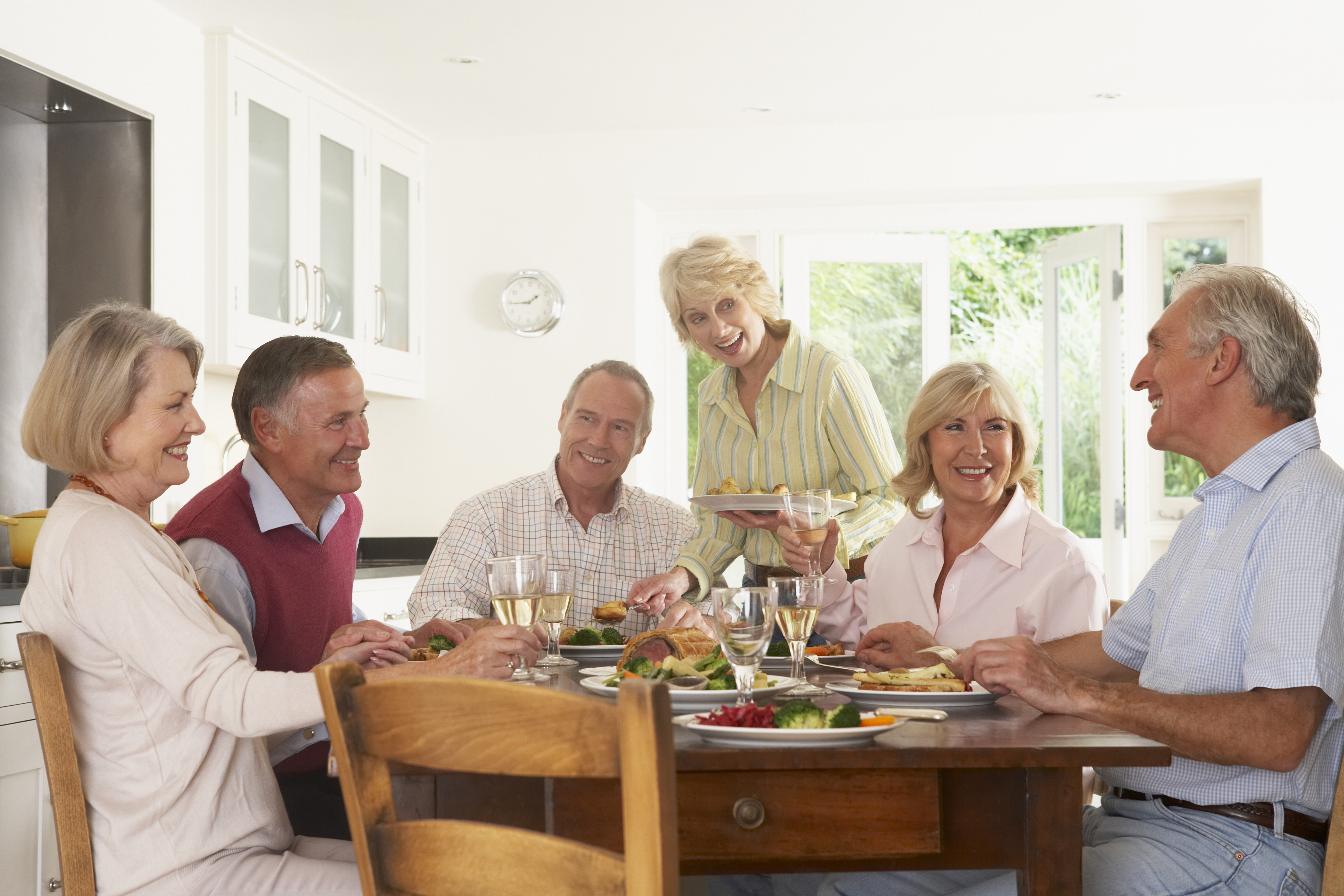 Mennesker der sidder ved bord, spiser og har det sjovt