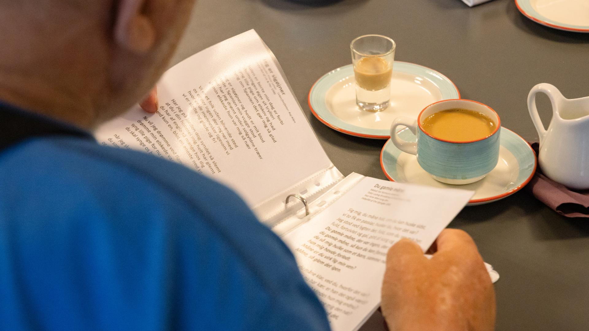 Et bord med en sangbog og kaffe på