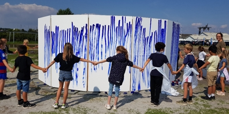 Børn i rundkreds omkring kunstværk