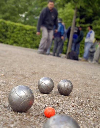 4 petanque kugler og en mand i baggrunden