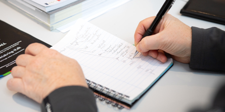 En der skriver notater på en blok